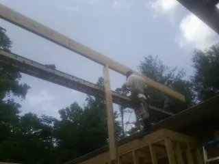 Carpenter setting a ridge beam over a new addition frame — Ice Dam Removal by Roofing Brothers in Perkasie