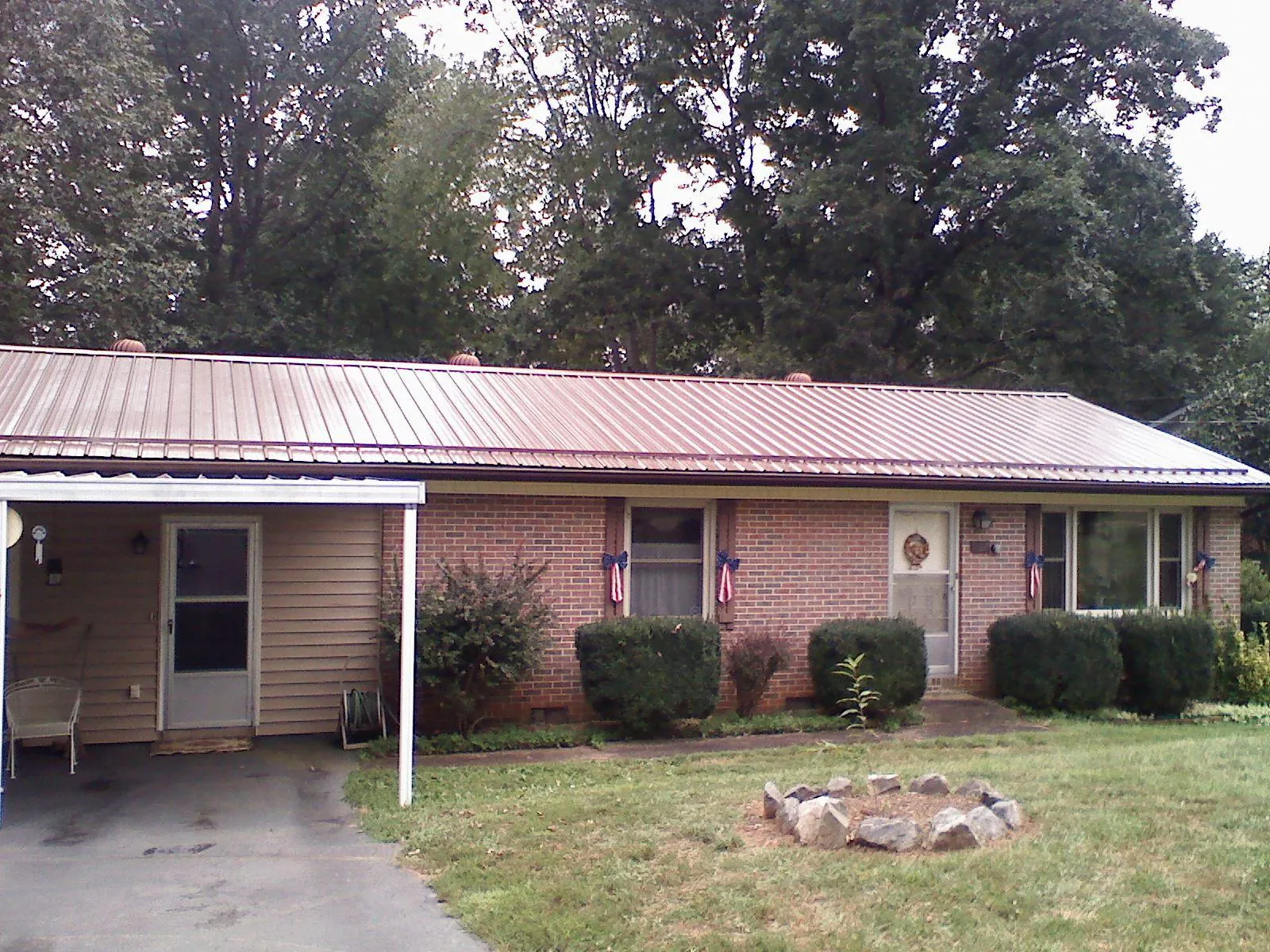 Bronze metal roof and carport on a brick ranch home — Roof Repair work by our crew in Perkasie